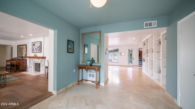 hall featuring built in shelves and light hardwood / wood-style floors