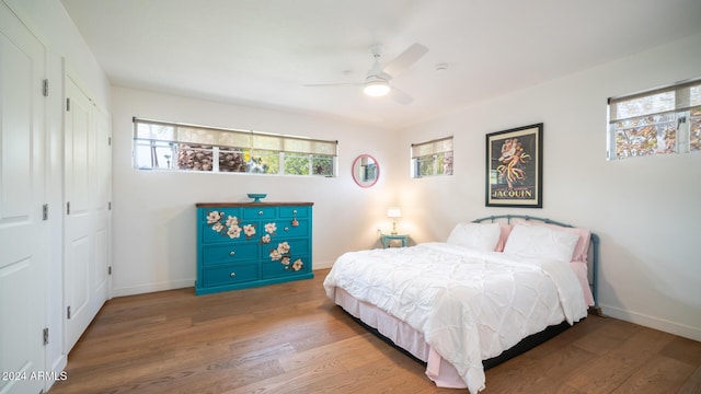 bedroom featuring multiple windows, ceiling fan, a closet, and hardwood / wood-style flooring