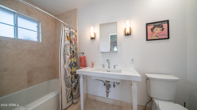 bathroom with tile patterned floors, shower / bath combo with shower curtain, and toilet