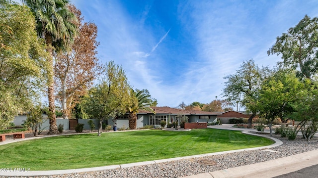 ranch-style home featuring a front lawn