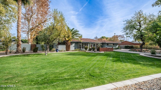 ranch-style home featuring a hot tub and a front lawn