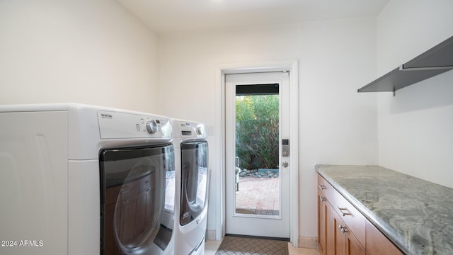 washroom with washer and dryer and cabinets