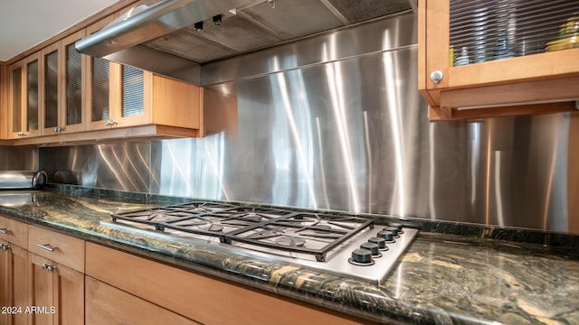 kitchen with backsplash, stainless steel gas cooktop, and dark stone counters