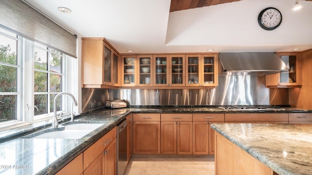 kitchen with decorative backsplash, appliances with stainless steel finishes, sink, wall chimney range hood, and stone counters