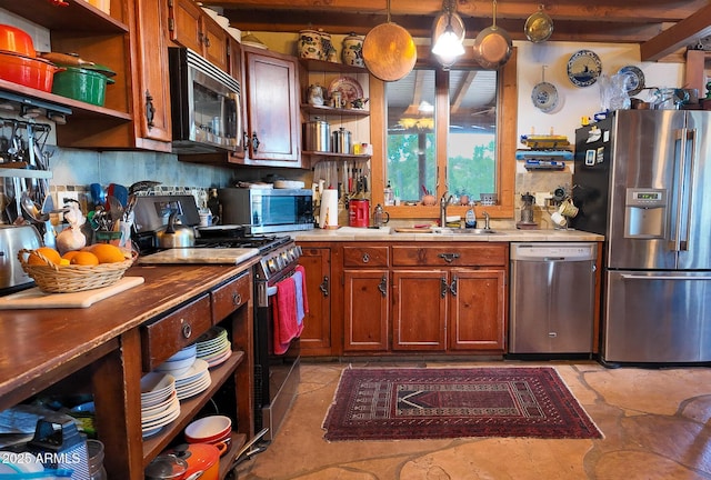 kitchen featuring stainless steel appliances, sink, pendant lighting, and tasteful backsplash