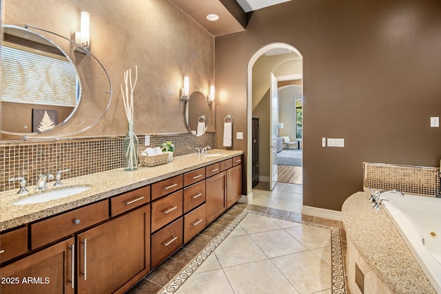 bathroom with backsplash, tiled bath, tile patterned floors, and vanity