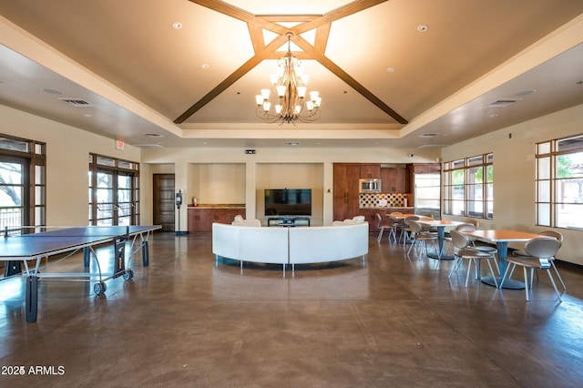 interior space featuring high vaulted ceiling, a raised ceiling, a notable chandelier, and french doors