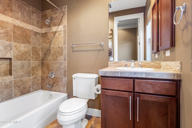 full bathroom featuring tiled shower / bath, vanity, and toilet