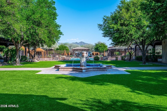 surrounding community featuring a lawn and a mountain view