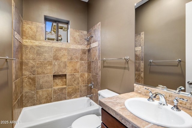 full bathroom featuring tiled shower / bath, vanity, and toilet