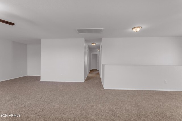 carpeted empty room with ceiling fan and plenty of natural light