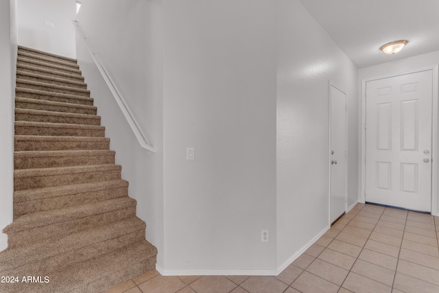 stairs featuring light tile patterned floors