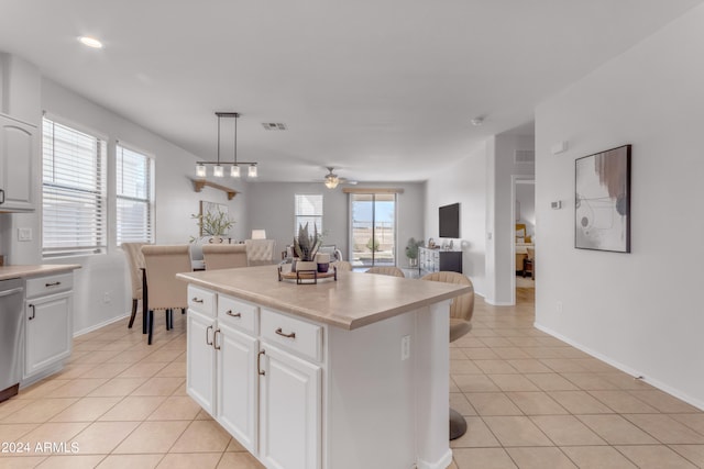 kitchen featuring white cabinetry, light tile patterned flooring, ceiling fan, pendant lighting, and a center island