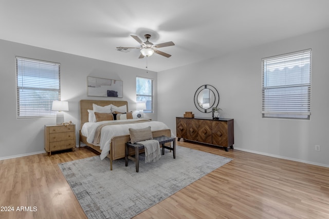 bedroom featuring multiple windows, light wood-type flooring, and ceiling fan