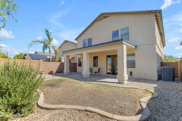 back of property with central AC and a patio area