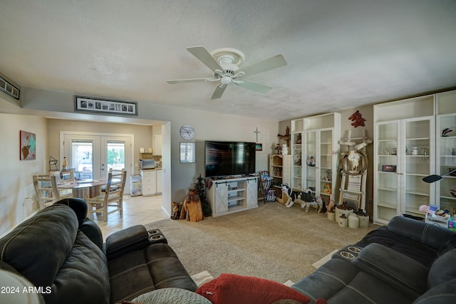 living room featuring light colored carpet, a textured ceiling, ceiling fan, and french doors