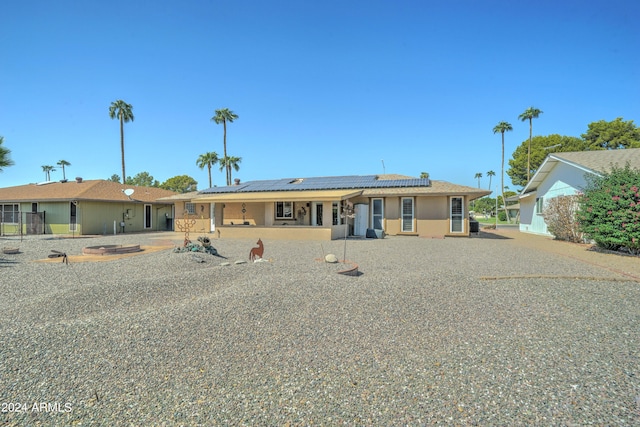 single story home with a patio and solar panels