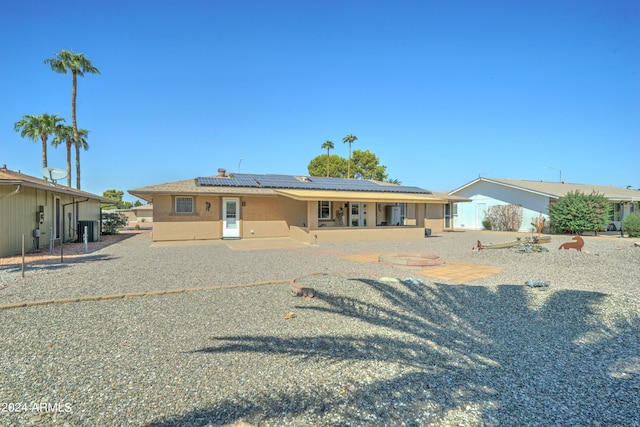 view of front of property with a patio, solar panels, and central AC