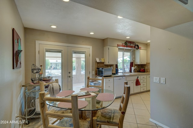 dining space featuring a textured ceiling, light tile patterned flooring, and french doors