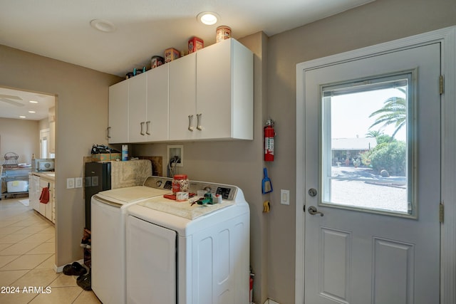 clothes washing area with ceiling fan, cabinets, light tile patterned floors, and washing machine and dryer