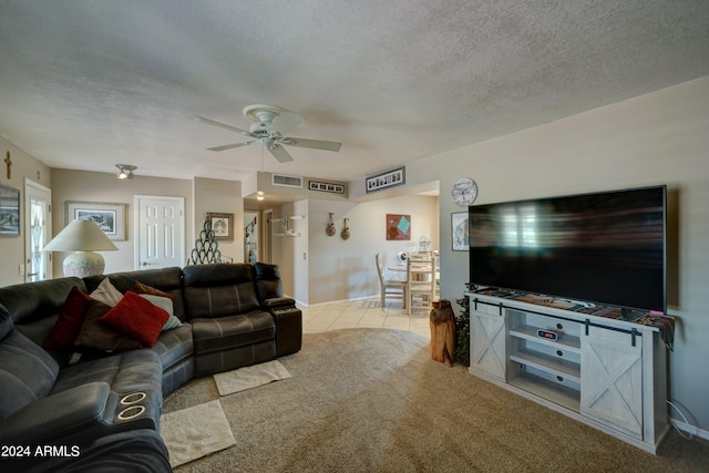 living room with a textured ceiling, light carpet, and ceiling fan