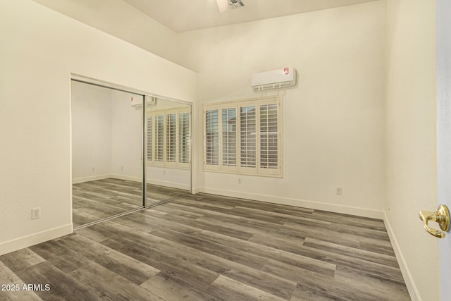 13609 W Vermont Ave, Litchfield Park, AZ 85340 - unfurnished bedroom featuring a closet, baseboards, a wall mounted air conditioner, and wood finished floors