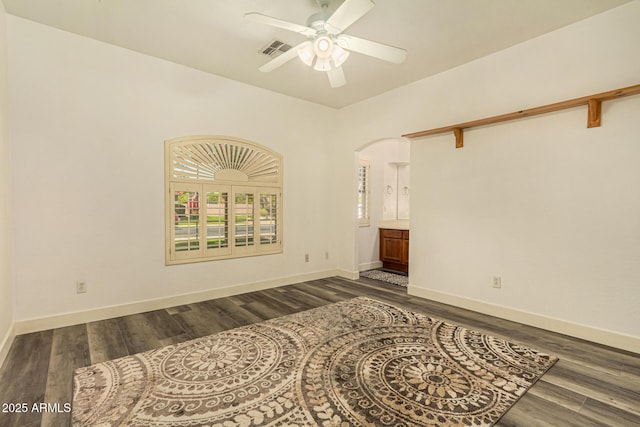 13609 W Vermont Ave, Litchfield Park, AZ 85340 - unfurnished bedroom with arched walkways, baseboards, visible vents, and wood finished floors