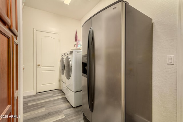 13609 W Vermont Ave, Litchfield Park, AZ 85340 - clothes washing area with light wood-style floors, a textured wall, laundry area, and separate washer and dryer