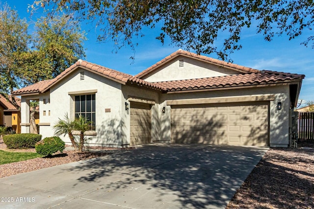 mediterranean / spanish-style home with concrete driveway, an attached garage, and stucco siding