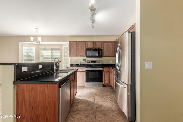 kitchen with tile patterned floors, stainless steel appliances, sink, decorative light fixtures, and an inviting chandelier