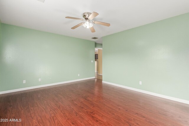 empty room featuring ceiling fan and dark hardwood / wood-style flooring