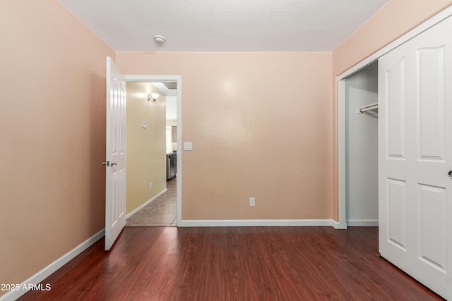 unfurnished bedroom with dark hardwood / wood-style flooring and a closet