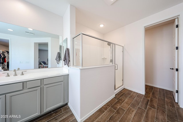 25051 N 140th Dr, Surprise, AZ 85387 - full bathroom with wood tiled floors, a stall shower, a spacious closet, vanity, and baseboards
