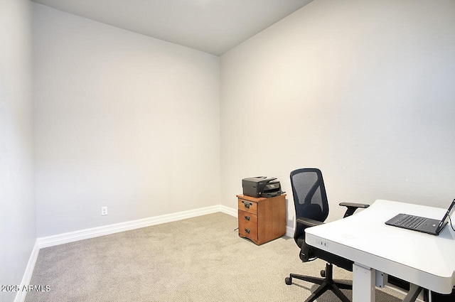 office space featuring light carpet and baseboards