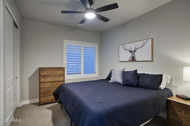 bedroom with ceiling fan, light colored carpet, visible vents, baseboards, and a closet