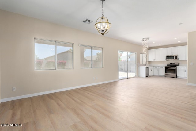 12426 W Adams St, Avondale, AZ 85323 - unfurnished living room with a chandelier, light wood finished floors, a sink, baseboards, and recessed lighting
