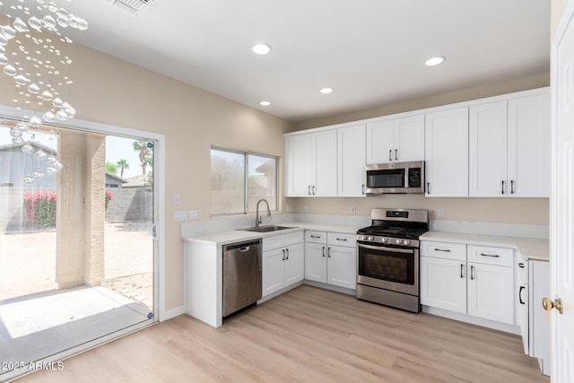 12426 W Adams St, Avondale, AZ 85323 - kitchen with appliances with stainless steel finishes, a sink, light wood-style flooring, white cabinets, and light countertops
