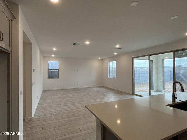 kitchen featuring an island with sink and light wood-type flooring