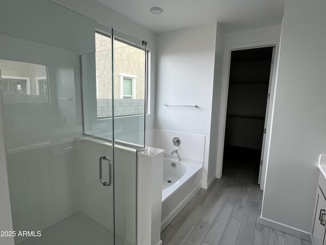 bathroom with vanity, plus walk in shower, and hardwood / wood-style floors