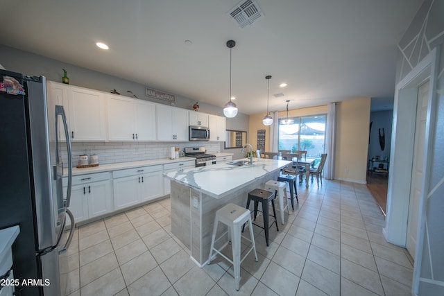 2361 N 212th Dr, Buckeye, AZ 85396 - kitchen featuring appliances with stainless steel finishes, light tile patterned floors, light countertops, white cabinetry, and recessed lighting
