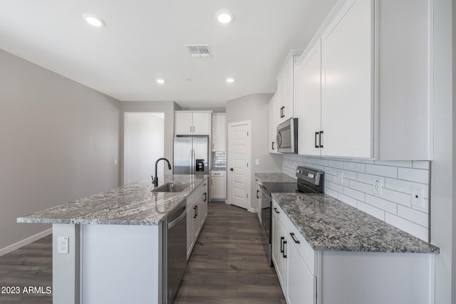 kitchen with white cabinets, stainless steel appliances, dark hardwood / wood-style floors, and an island with sink