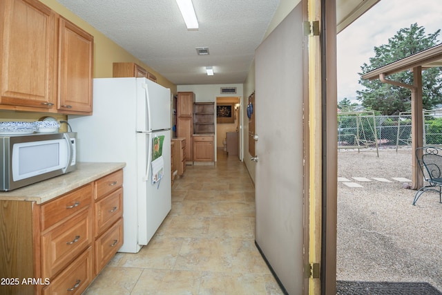 1170 N Broken Wagon Trl, Dewey, AZ 86327 - kitchen with white appliances, stone finish flooring, light countertops, and a textured ceiling
