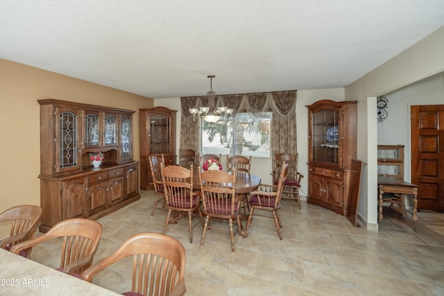 1170 N Broken Wagon Trl, Dewey, AZ 86327 - dining space with a chandelier, a textured ceiling, stone finish floors, and baseboards