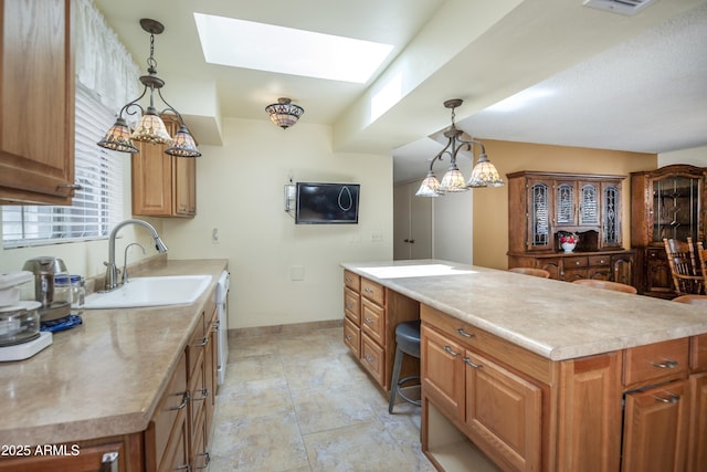1170 N Broken Wagon Trl, Dewey, AZ 86327 - kitchen with a sink, a skylight, light countertops, baseboards, and brown cabinets