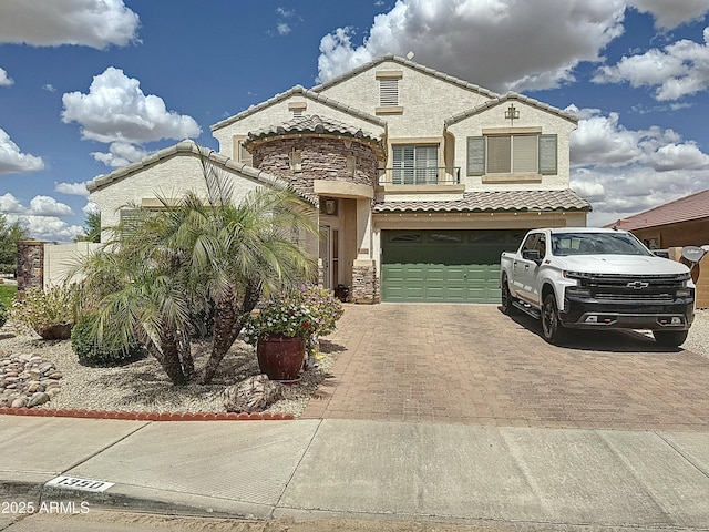 1350 E Racine Dr, Casa Grande, AZ 85122 - view of front of home with an attached garage, stone siding, a tile roof, stucco siding, and decorative driveway