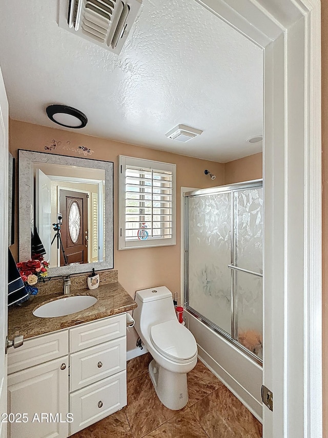 1350 E Racine Dr, Casa Grande, AZ 85122 - bathroom with combined bath / shower with glass door, vanity, a textured ceiling, toilet, and visible vents