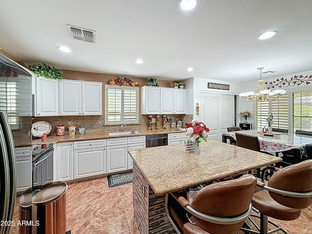 1350 E Racine Dr, Casa Grande, AZ 85122 - kitchen featuring white cabinets, visible vents, a chandelier, dishwasher, and backsplash