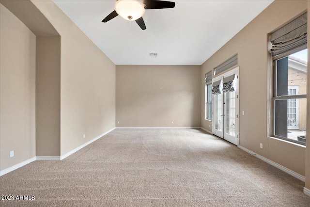 empty room with ceiling fan, carpet floors, and french doors