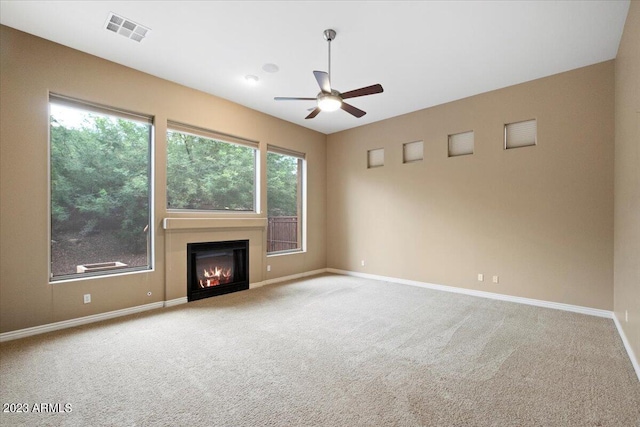 unfurnished living room featuring light colored carpet and ceiling fan