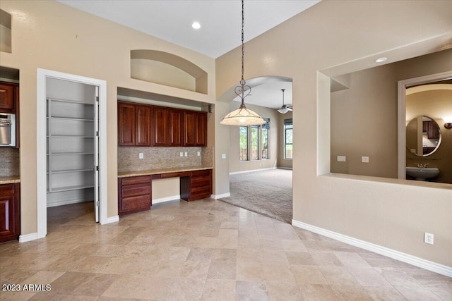 kitchen featuring pendant lighting, light carpet, sink, built in shelves, and decorative backsplash